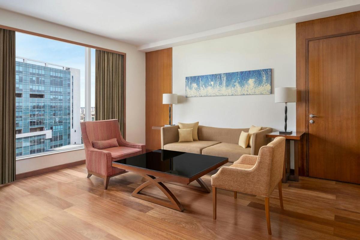 a living room with a couch and chairs and a table at Bengaluru Marriott Hotel Whitefield in Bengaluru