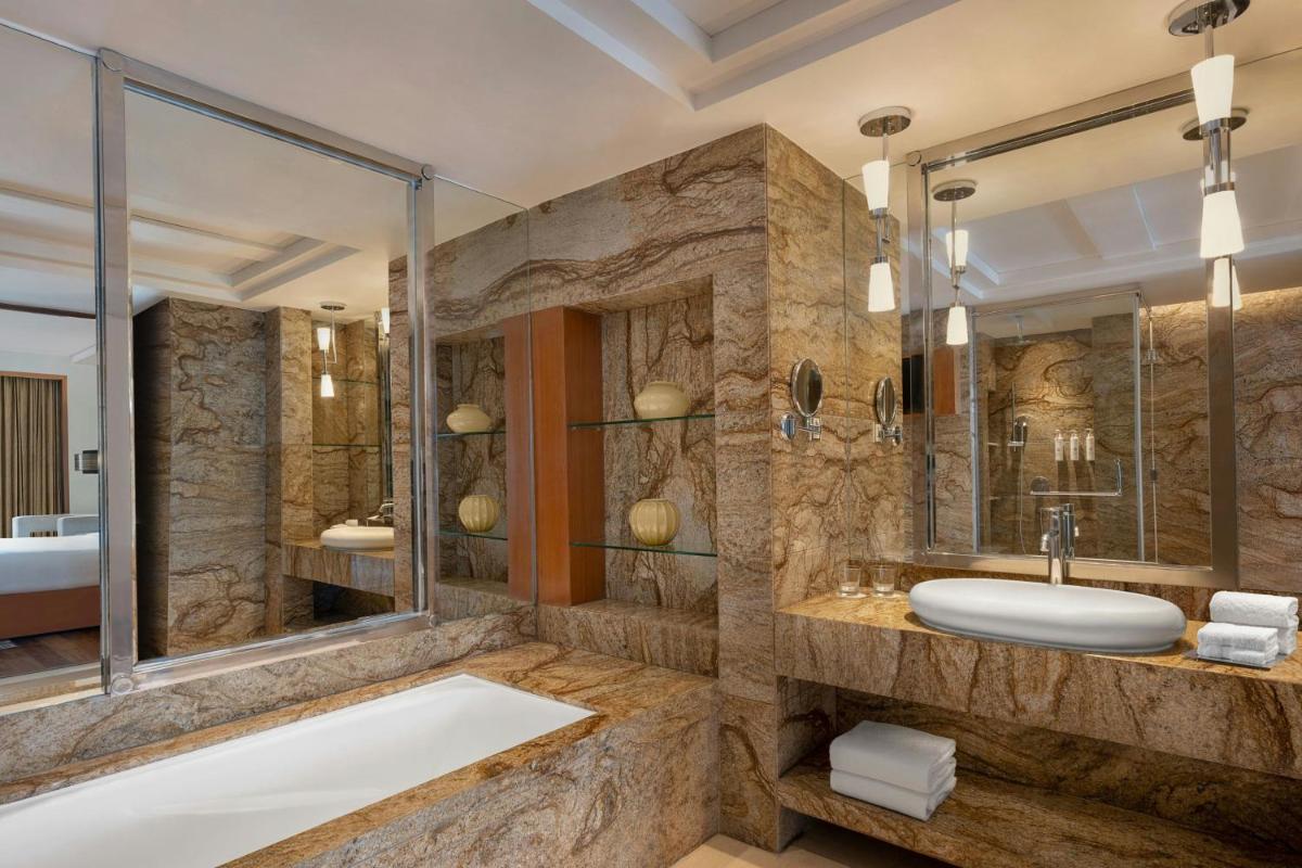 a bathroom with a tub and a sink at Bengaluru Marriott Hotel Whitefield in Bengaluru