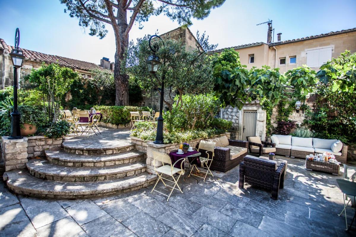une terrasse avec des escaliers, des tables et des chaises dans l'établissement La Regalido, à Fontvieille