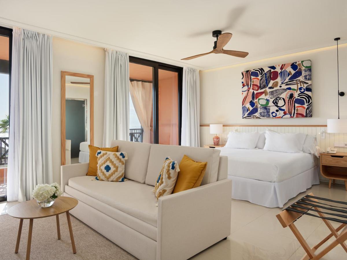 Sala de estar blanca con cama y sofá en H10 Costa Adeje Palace, en Adeje