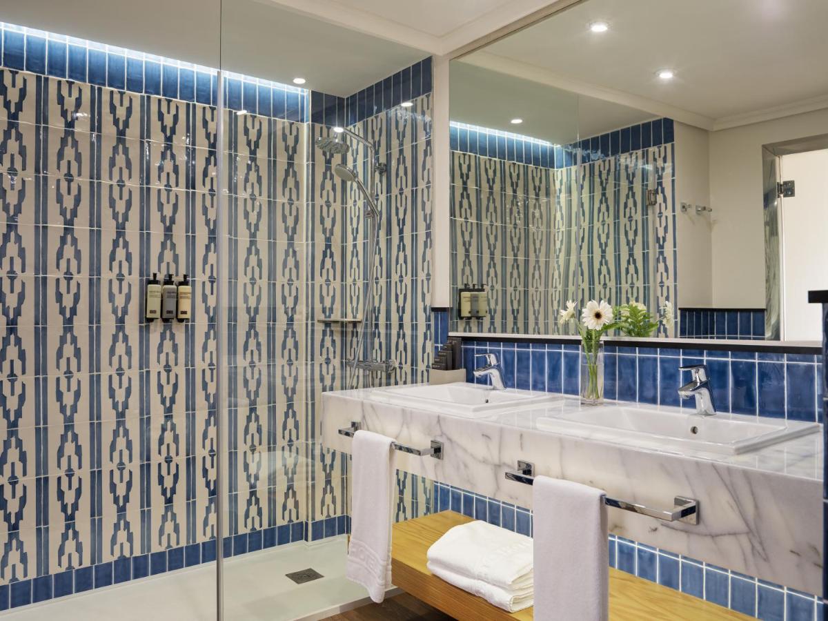 un baño con lavabo y espejo en H10 Costa Adeje Palace, en Adeje