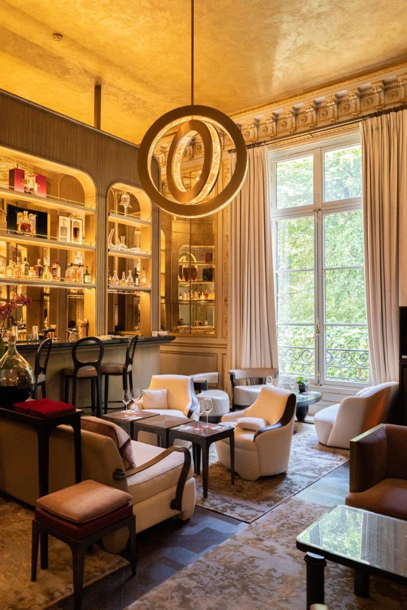 un salon rempli de meubles et d'un lustre dans l'établissement Maison Villeroy, à Paris