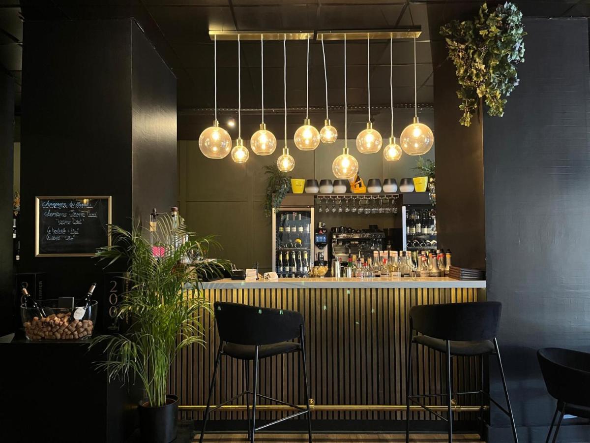 un bar avec deux chaises et un comptoir avec des lumières dans l'établissement HOTEL & SPA Le Renard Centre, à Châlons-en-Champagne