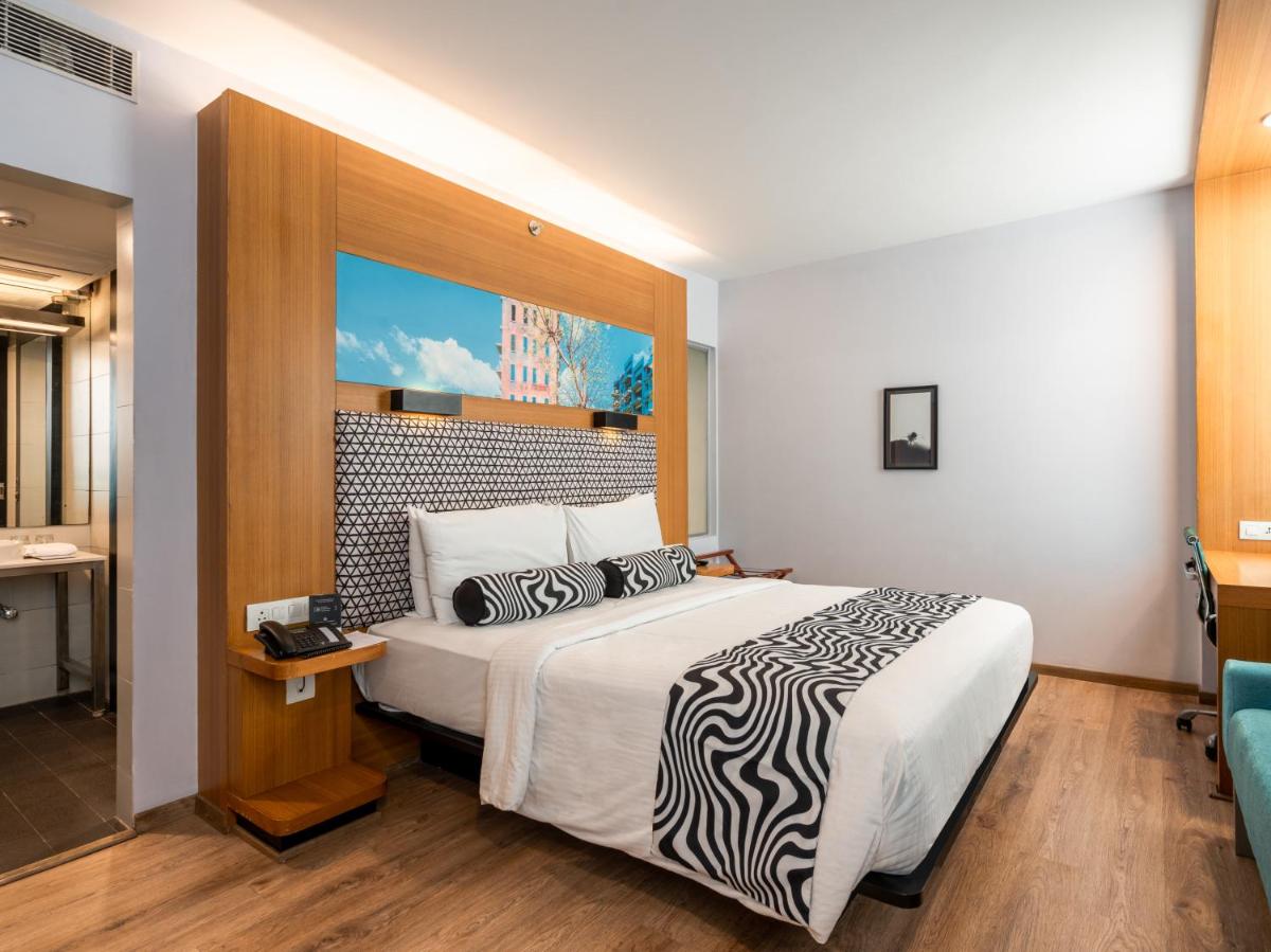 a hotel room with a bed and a bathroom at Sunday Hotel Chandigarh Zirakpur in Zirakpur