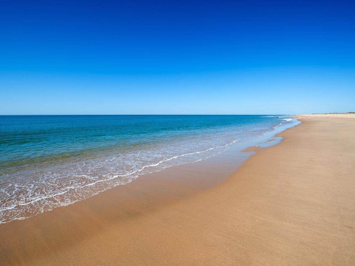 una playa vacía con el océano en el fondo en Hotel Fuerte El Rompido, en El Rompido