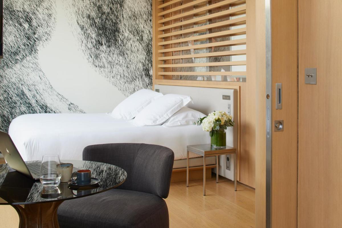 une chambre d'hôtel avec un lit et une table avec une chaise dans l'établissement Le Cinq Codet, à Paris 37 autres photos une chambre d'hôtel avec un lit et une table avec une chaise dans l'établissement Le Cinq Codet, à Paris 37 autres photos