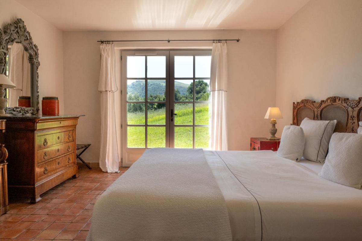 une chambre avec un grand lit et une grande fenêtre dans l'établissement Auberge Ostapé, à Bidarray 52 autres photos
