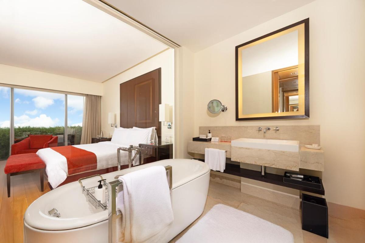 a hotel bathroom with a bed and a tub and a sink at Trident Hyderabad in Hyderabad