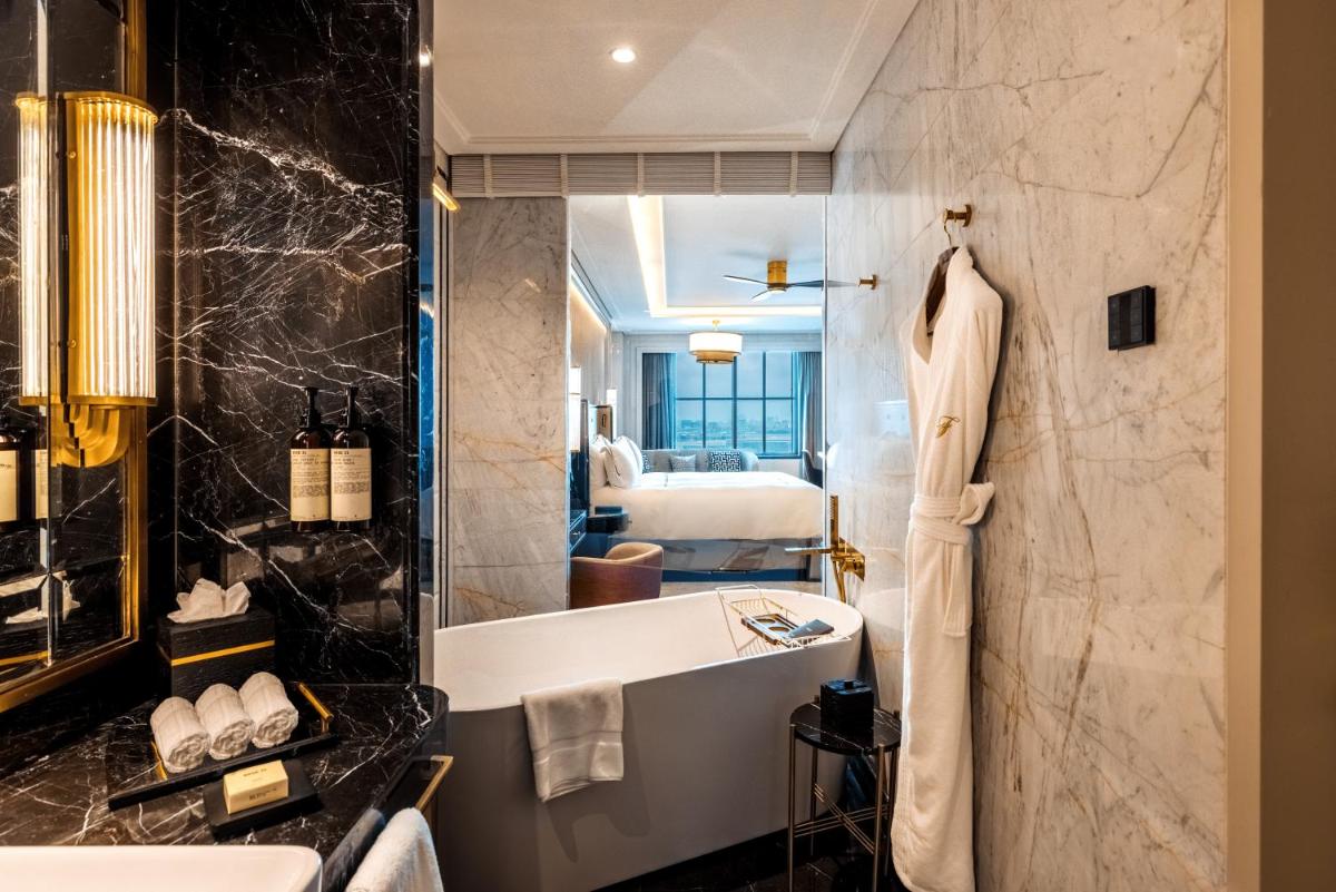 a bathroom with a tub and a sink and a mirror at Fairmont Mumbai in Mumbai