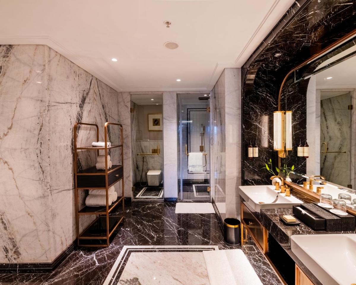 a bathroom with two sinks and a large mirror at Fairmont Mumbai in Mumbai