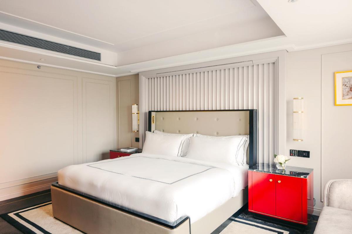 a bedroom with a large white bed and a red cabinet at Fairmont Mumbai in Mumbai