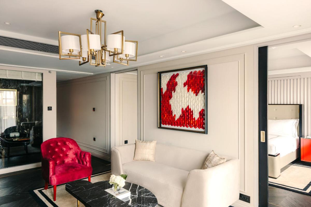 a living room with a white couch and a red chair at Fairmont Mumbai in Mumbai