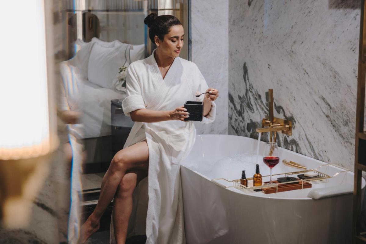a woman sitting in a bathtub in a hotel room at Fairmont Mumbai in Mumbai