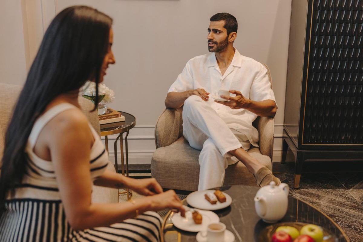 a man sitting in a chair talking to a woman at Fairmont Mumbai in Mumbai