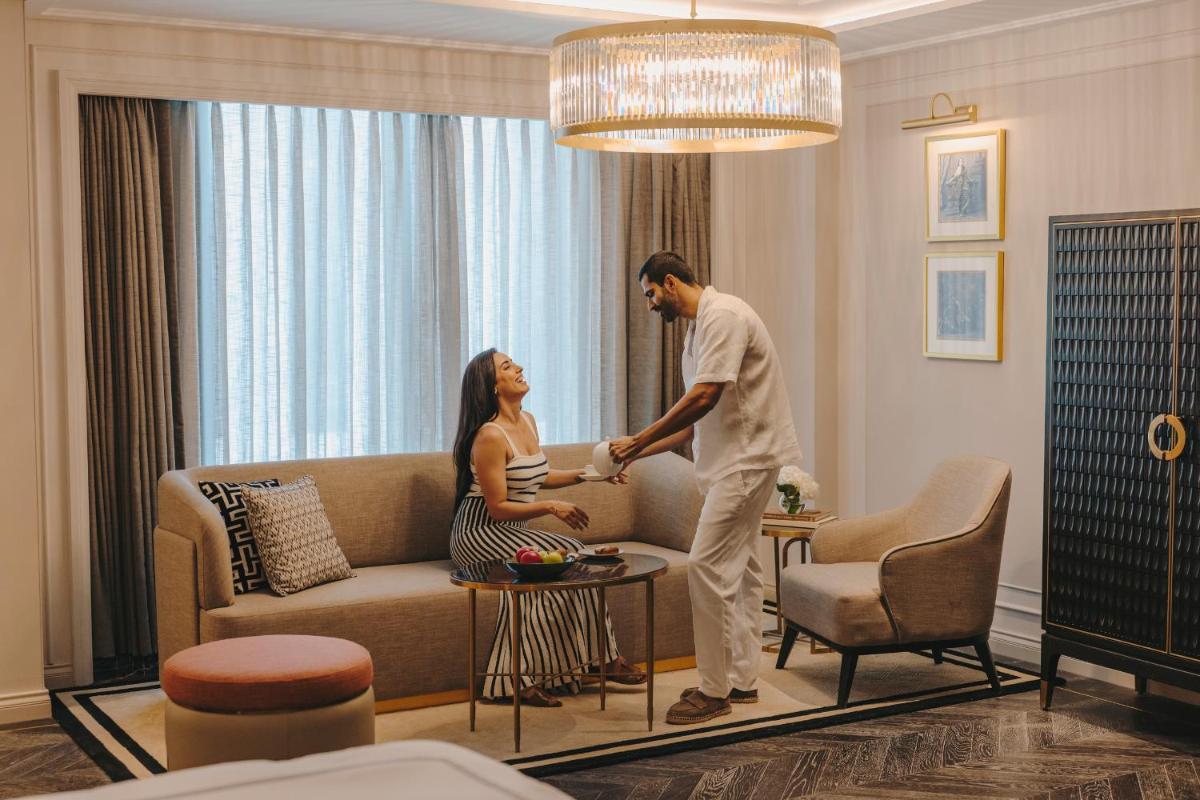 a man standing next to a woman in a living room at Fairmont Mumbai in Mumbai