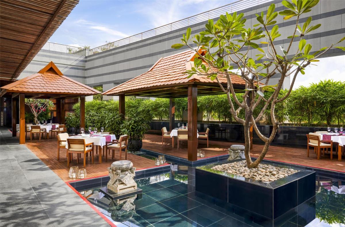 a restaurant with a tree in the middle of a courtyard at Grand Hyatt Mumbai Hotel and Residences in Mumbai