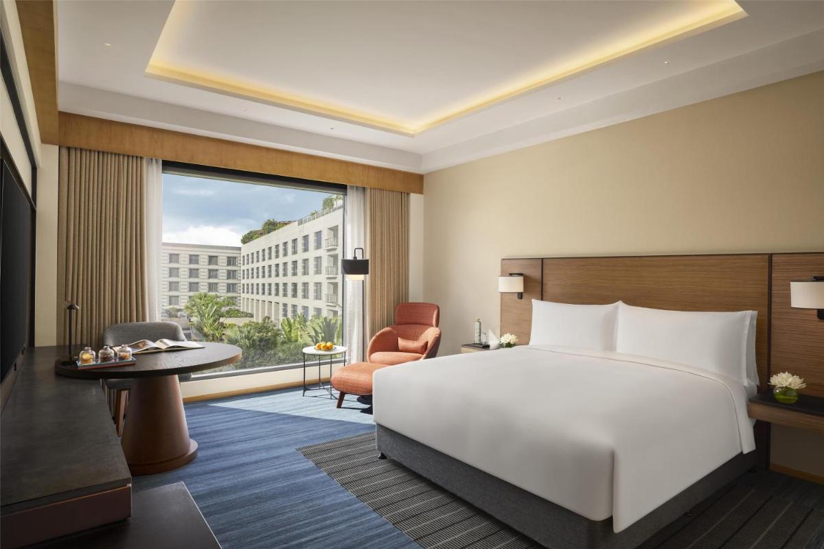 a bedroom with a bed and a desk and a chair at Grand Hyatt Mumbai Hotel and Residences in Mumbai