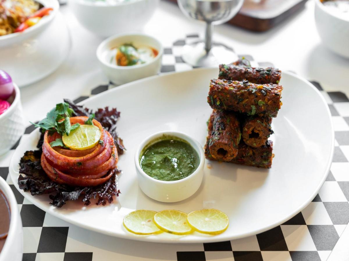 a white plate with food on a table at Sunday Hotel Chandigarh Zirakpur in Zirakpur