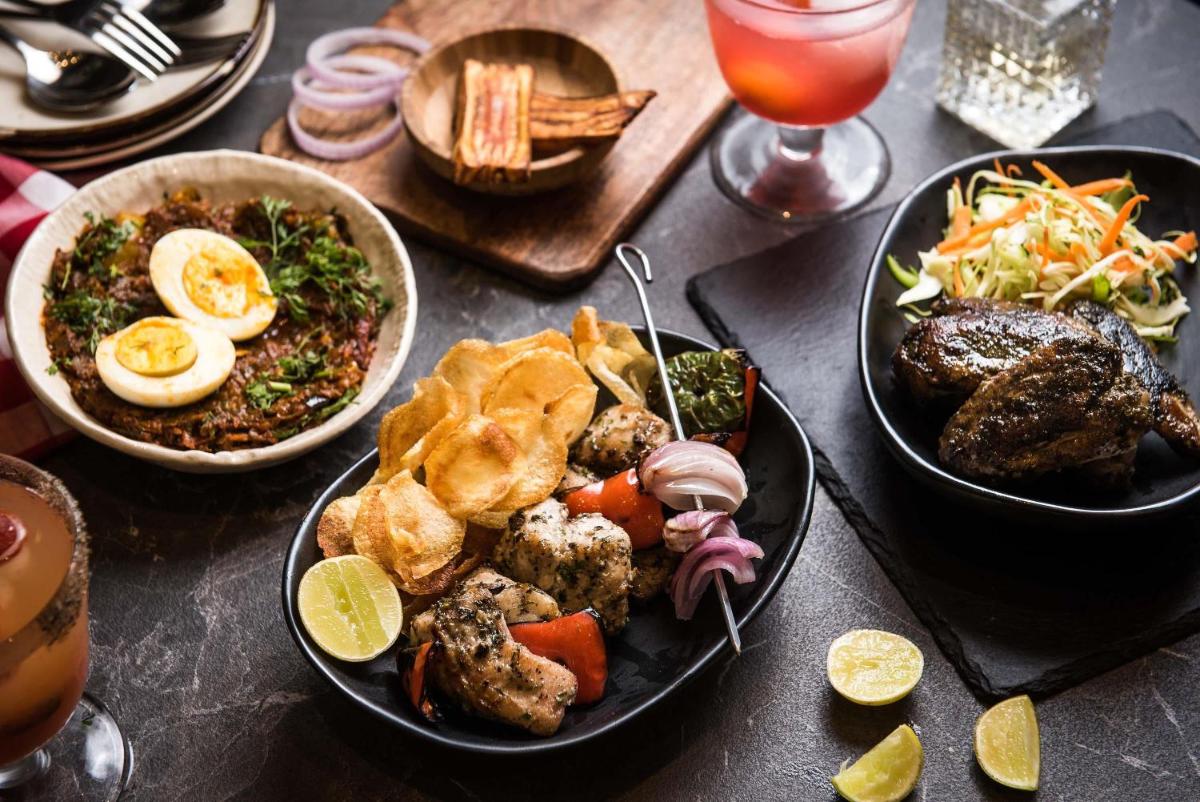 a table with plates of food and bowls of food at Hyatt Centric Candolim Goa in Calangute a table with plates of food and bowls of food at Hyatt Centric Candolim Goa in Calangute