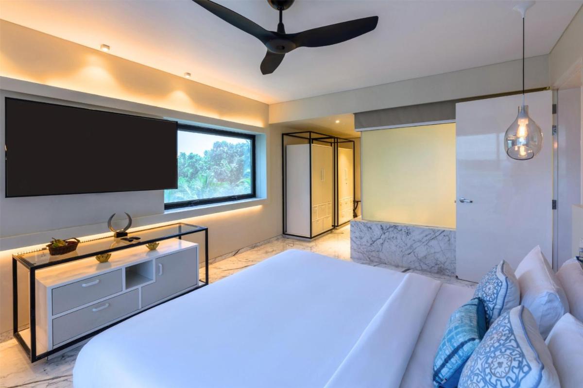 a bedroom with a large bed and a flat screen tv at Hyatt Centric Candolim Goa in Calangute a bedroom with a large bed and a flat screen tv at Hyatt Centric Candolim Goa in Calangute