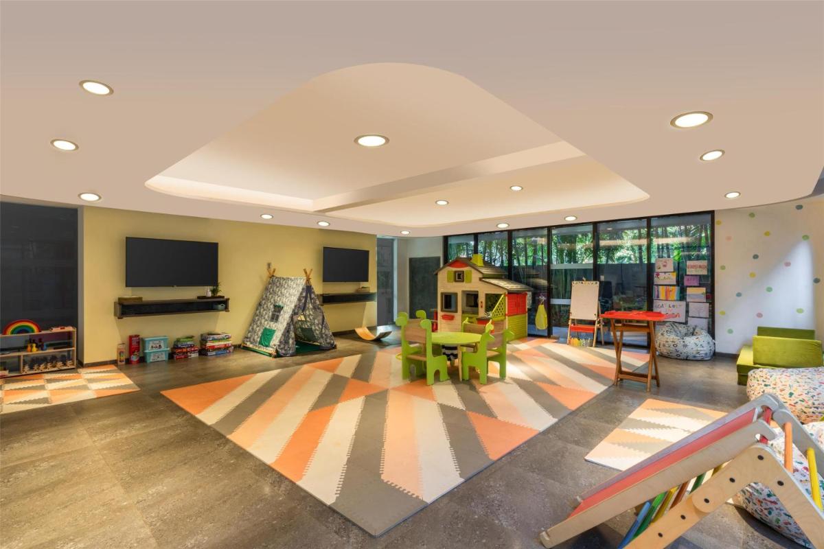 a childrens play room with a slide and a playground at Hyatt Centric Candolim Goa in Calangute a childrens play room with a slide and a playground at Hyatt Centric Candolim Goa in Calangute