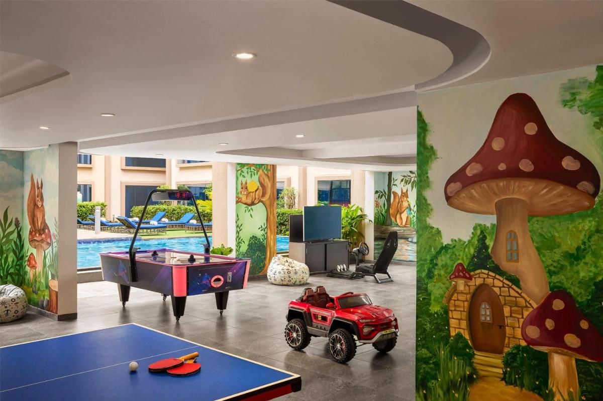 a room with a ping pong table and mushroom mural at Hyatt Centric Candolim Goa in Calangute a room with a ping pong table and mushroom mural at Hyatt Centric Candolim Goa in Calangute