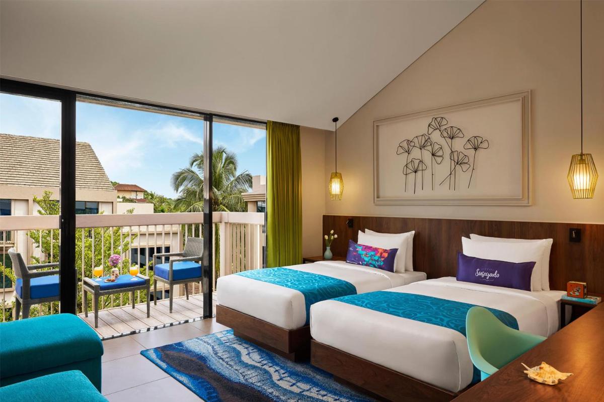 two beds in a hotel room with a balcony at Hyatt Centric Candolim Goa in Calangute two beds in a hotel room with a balcony at Hyatt Centric Candolim Goa in Calangute