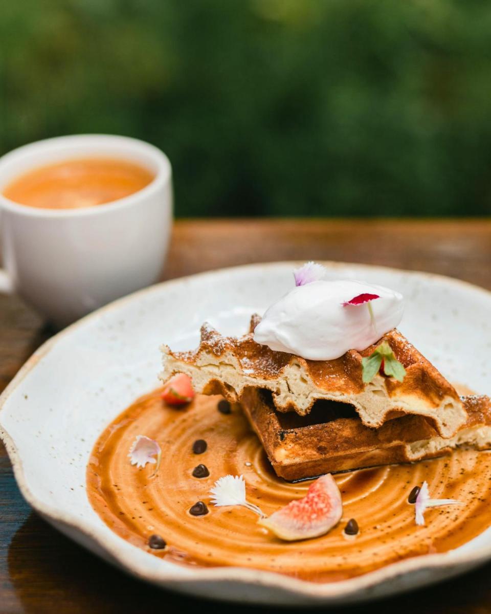 a plate with a piece of toast with whipped cream and a cup of coffee at Hyatt Centric Candolim Goa in Calangute a plate with a piece of toast with whipped cream and a cup of coffee at Hyatt Centric Candolim Goa in Calangute