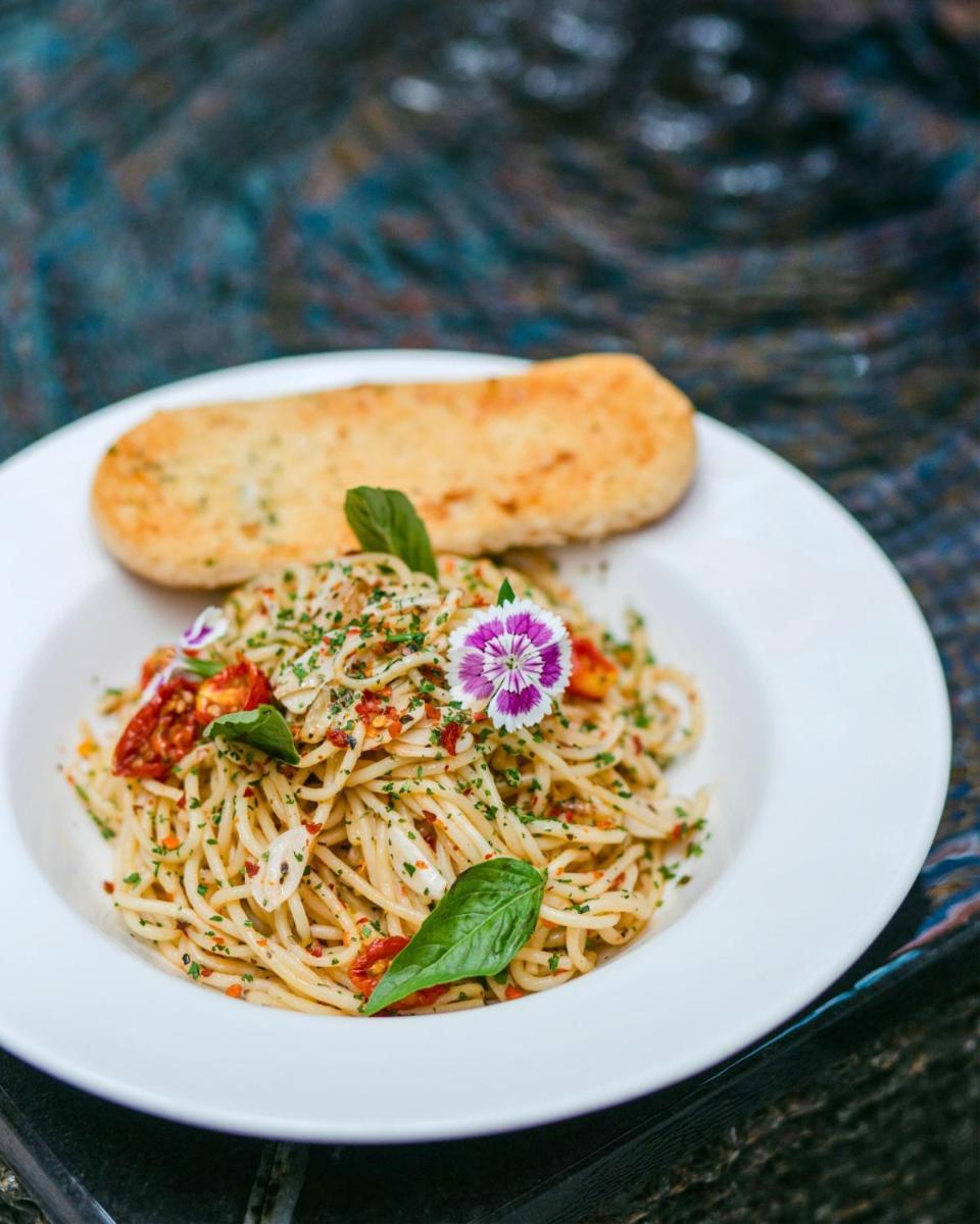 a plate of food with pasta and a piece of bread at Hyatt Centric Candolim Goa in Calangute a plate of food with pasta and a piece of bread at Hyatt Centric Candolim Goa in Calangute