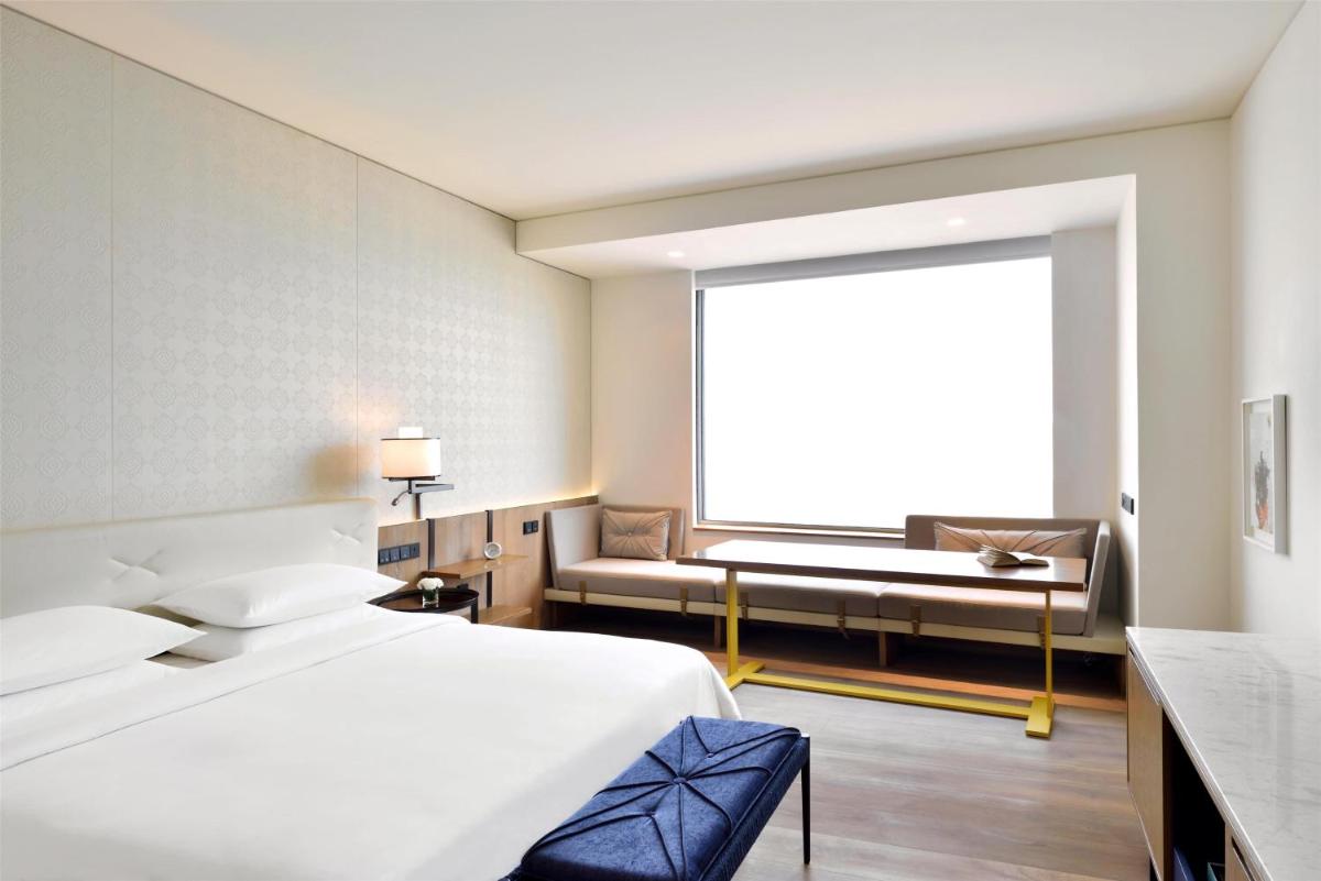 a hotel room with a bed and a window at Andaz Delhi, by Hyatt in New Delhi a hotel room with a bed and a window at Andaz Delhi, by Hyatt in New Delhi