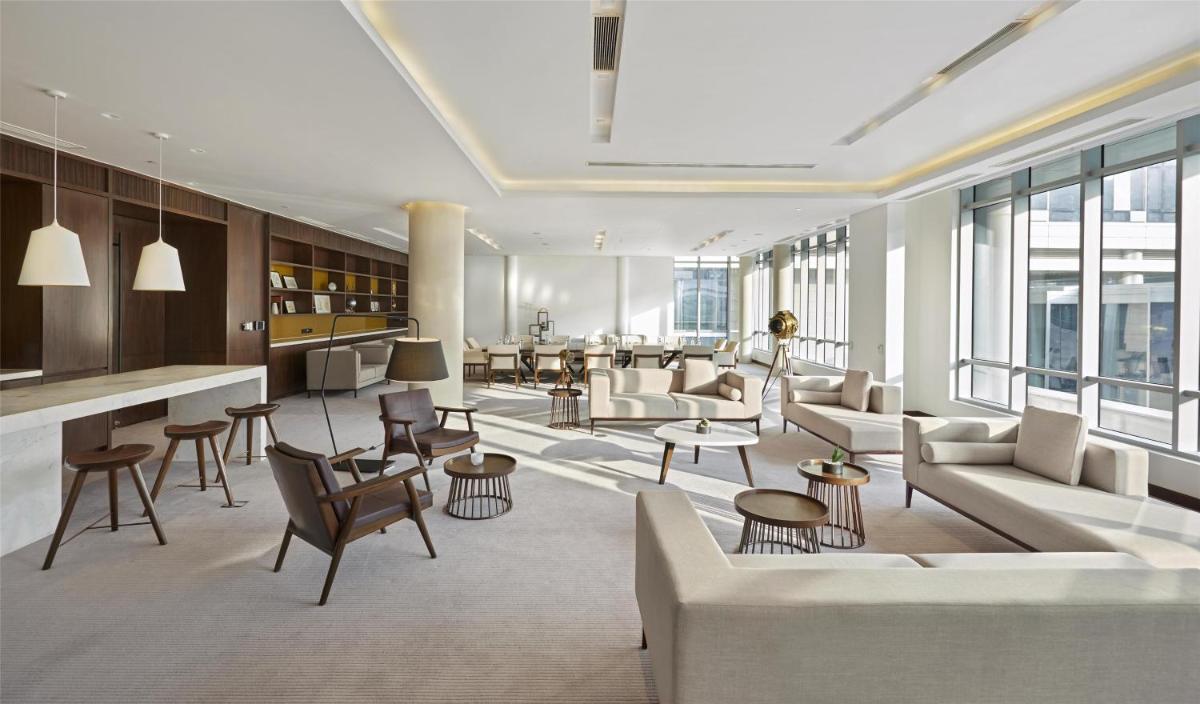 a lobby with couches and chairs and a bar at Andaz Delhi, by Hyatt in New Delhi a lobby with couches and chairs and a bar at Andaz Delhi, by Hyatt in New Delhi