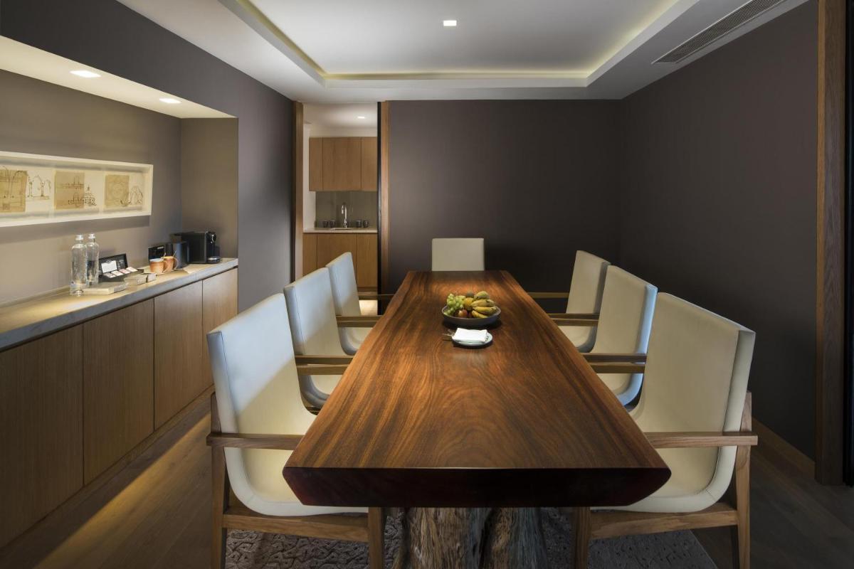 a dining room with a wooden table and chairs at Andaz Delhi, by Hyatt in New Delhi a dining room with a wooden table and chairs at Andaz Delhi, by Hyatt in New Delhi