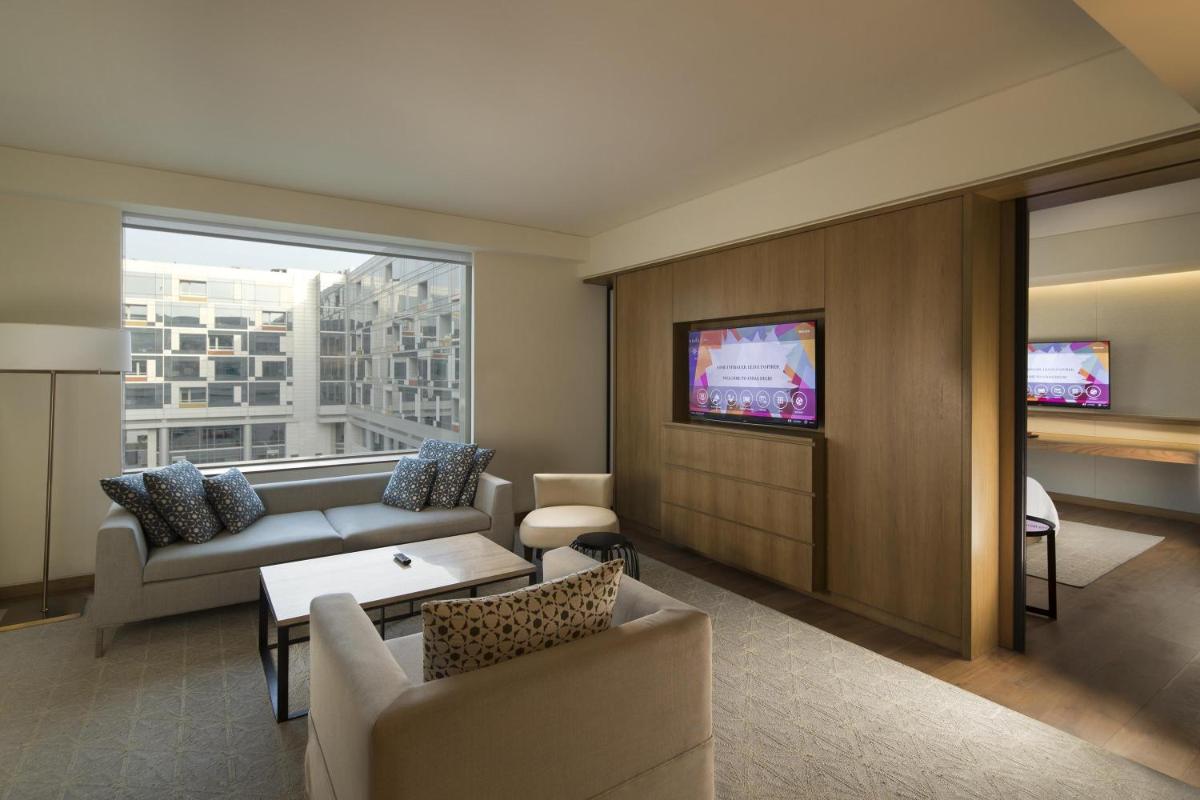 a living room with a couch and a tv at Andaz Delhi, by Hyatt in New Delhi a living room with a couch and a tv at Andaz Delhi, by Hyatt in New Delhi