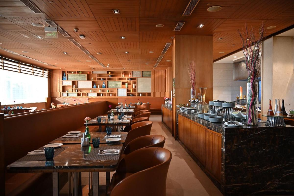 a dining room with long tables and leather chairs at Holiday Inn New Delhi Mayur Vihar Noida by IHG in New Delhi a dining room with long tables and leather chairs at Holiday Inn New Delhi Mayur Vihar Noida by IHG in New Delhi