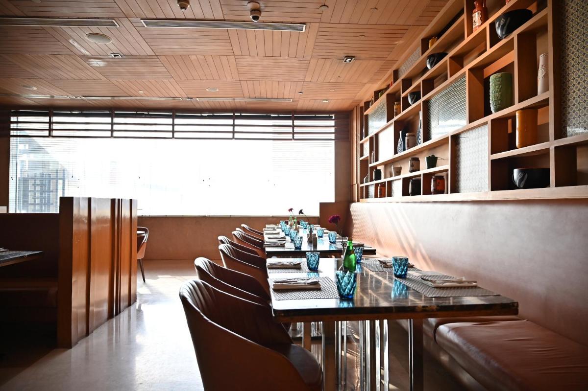 a dining room with a long table and chairs at Holiday Inn New Delhi Mayur Vihar Noida by IHG in New Delhi a dining room with a long table and chairs at Holiday Inn New Delhi Mayur Vihar Noida by IHG in New Delhi