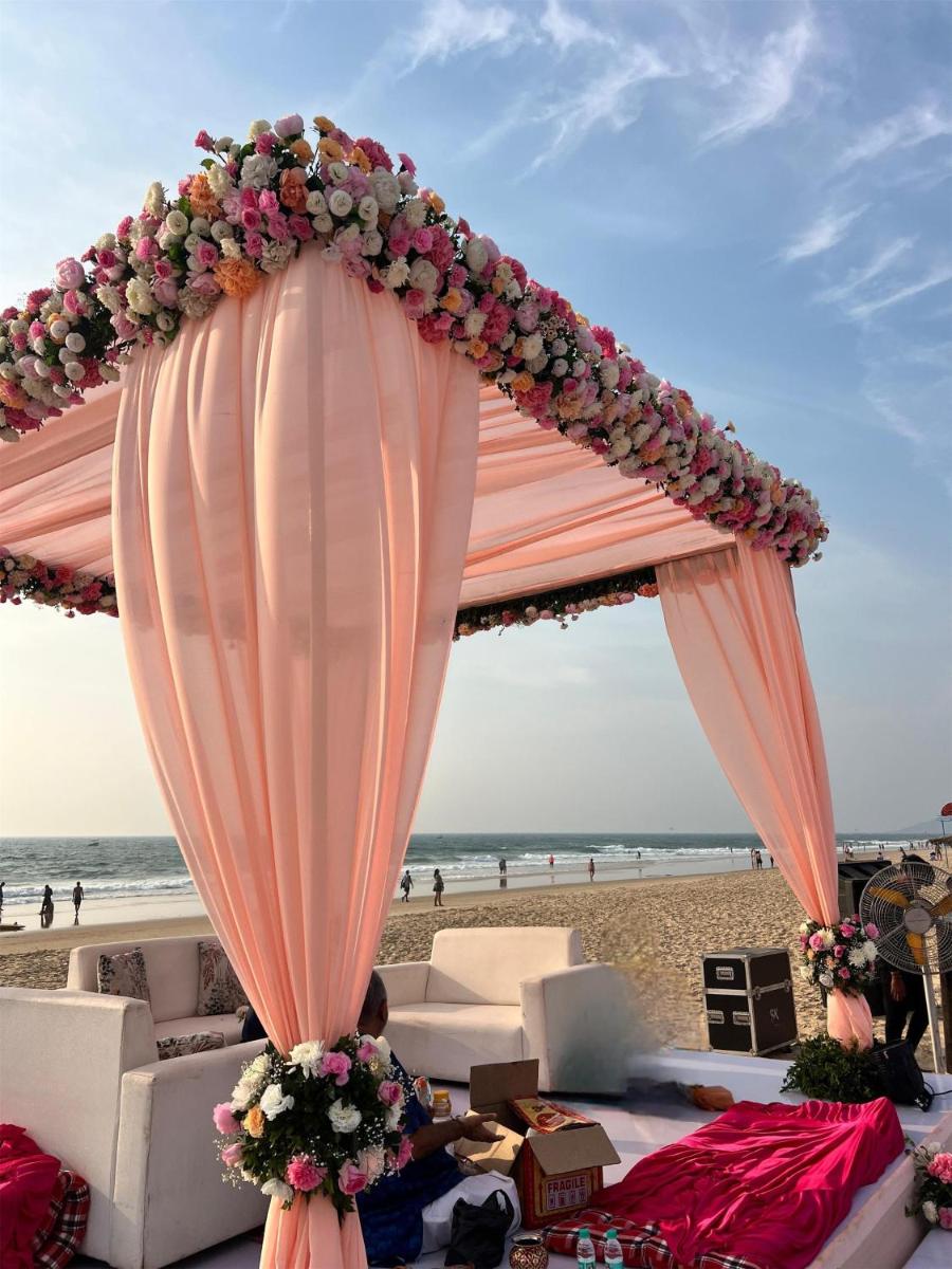 a tent on the beach with flowers and a canopy at Radisson Goa Candolim in Candolim