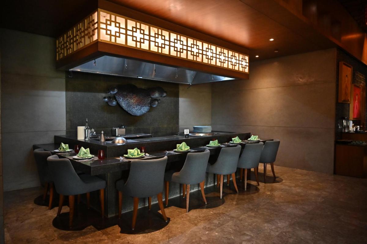 a dining room with a long table and chairs at Holiday Inn New Delhi Mayur Vihar Noida by IHG in New Delhi a dining room with a long table and chairs at Holiday Inn New Delhi Mayur Vihar Noida by IHG in New Delhi