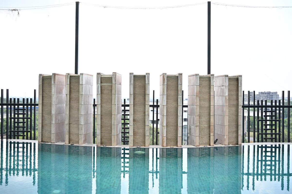 a swimming pool in front of a building at Holiday Inn New Delhi Mayur Vihar Noida by IHG in New Delhi a swimming pool in front of a building at Holiday Inn New Delhi Mayur Vihar Noida by IHG in New Delhi