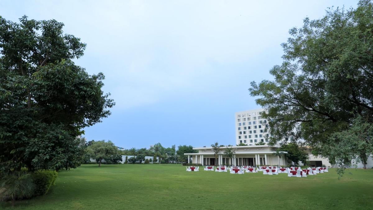 a large lawn with white chairs in front of a building at DoubleTree By Hilton Jaipur Amer in Jaipur