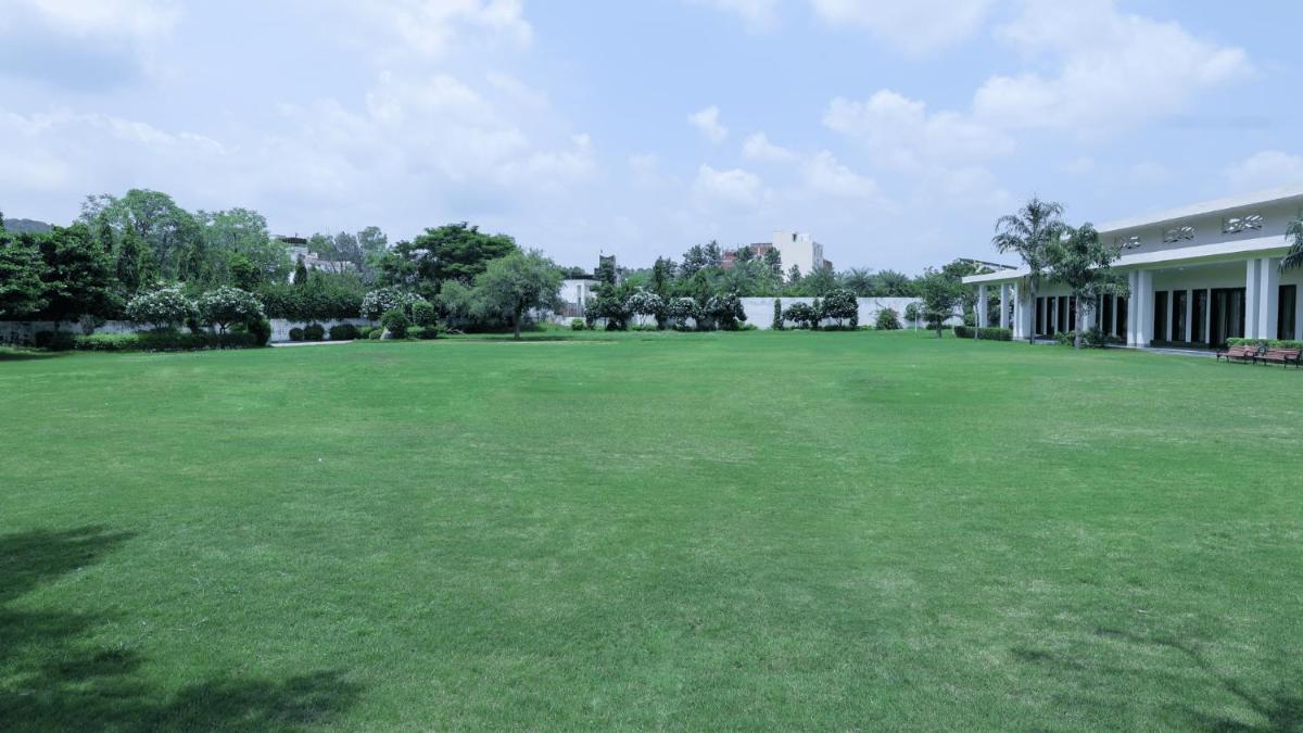 a large yard of a house with a large green field at DoubleTree By Hilton Jaipur Amer in Jaipur