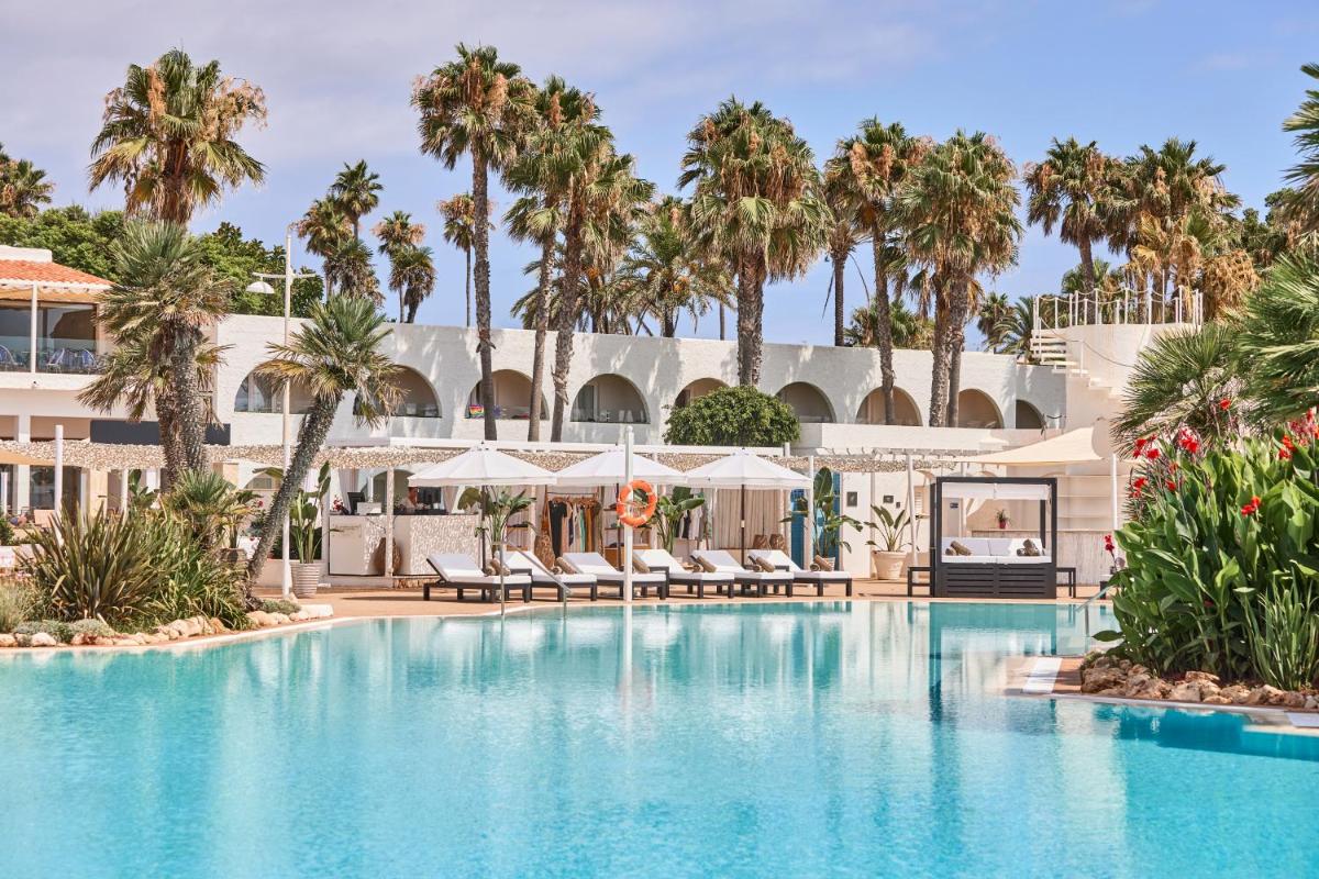 una piscina en el resort con palmeras en AluaSoul Menorca - Adults Only, en S'Algar
