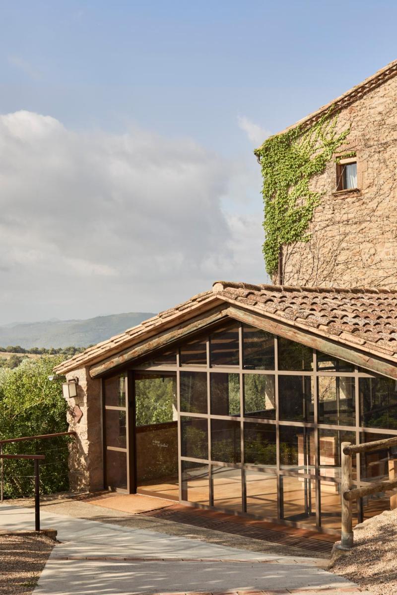 Un edificio con puertas de vidrio y una hiedra creciendo en él. en La Garriga de Castelladral, en Castelladral