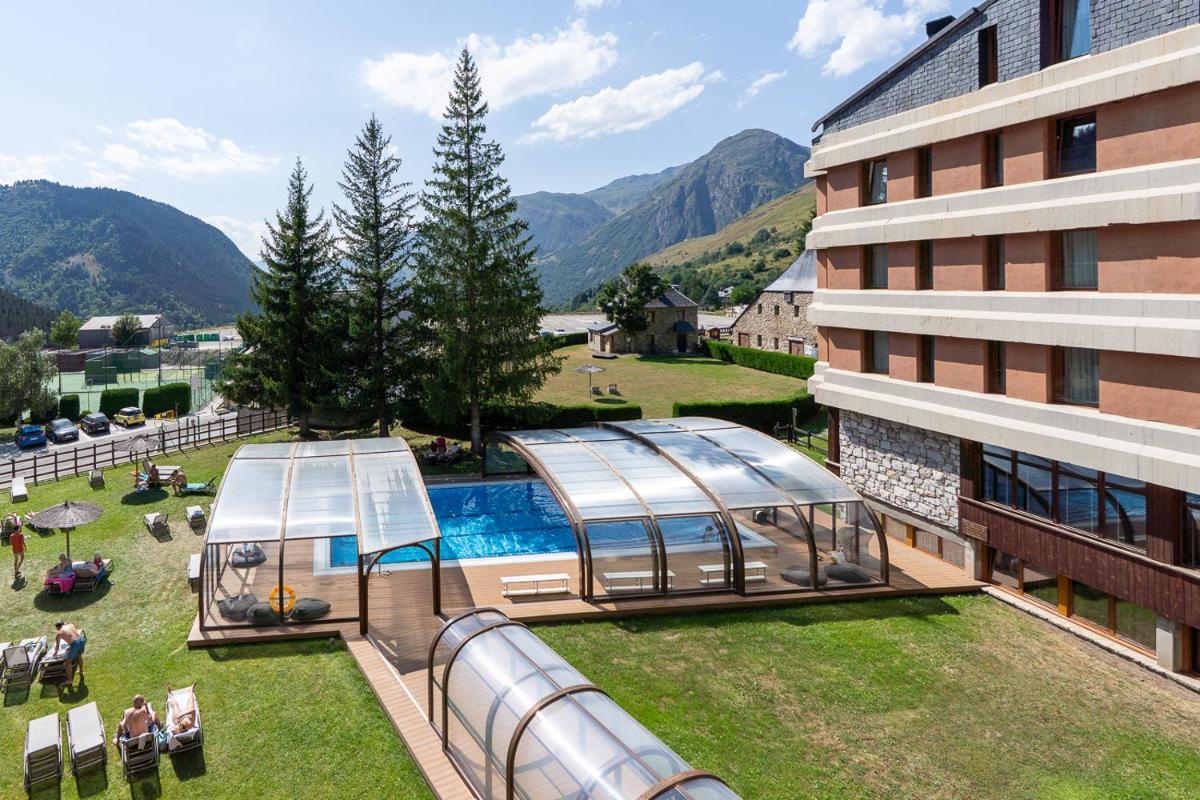 Un complejo con piscina y un edificio. en Hotel Montarto, en Baqueira Beret
