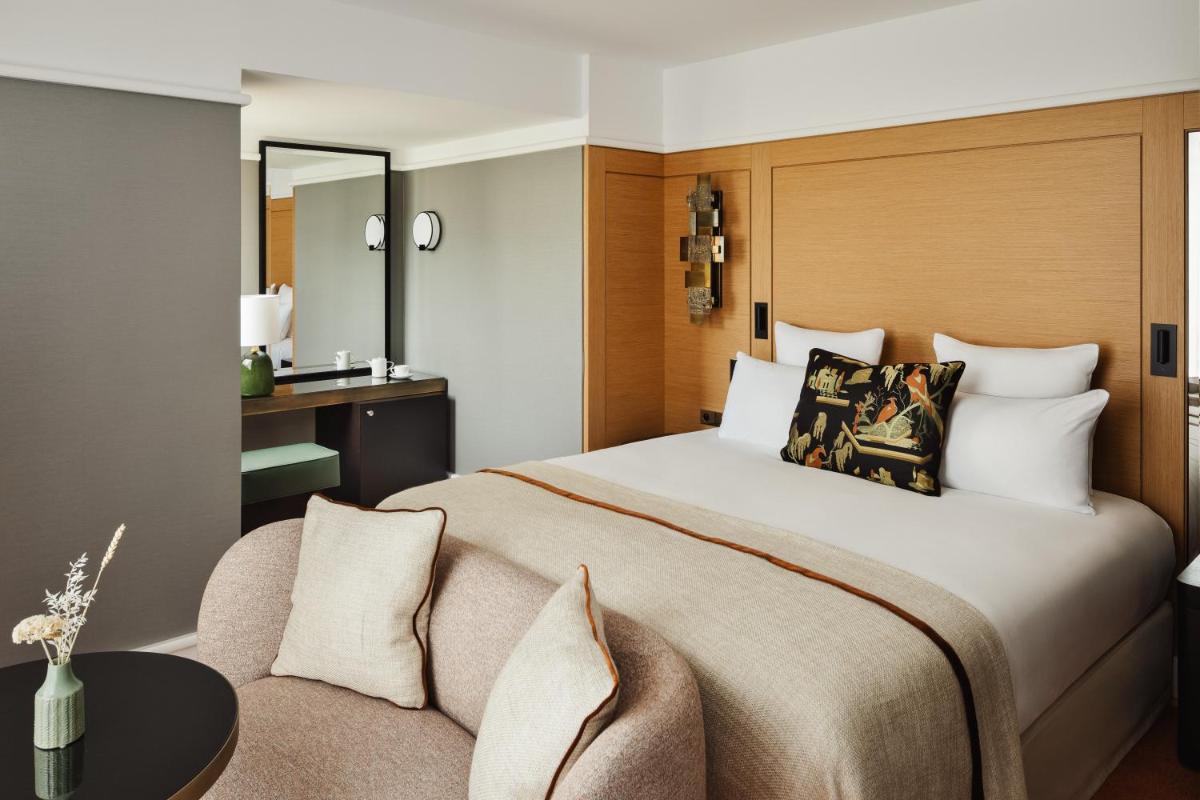 une chambre avec un grand lit et un canapé dans l'établissement Hôtel De Sers Champs Elysées Paris, à Paris
