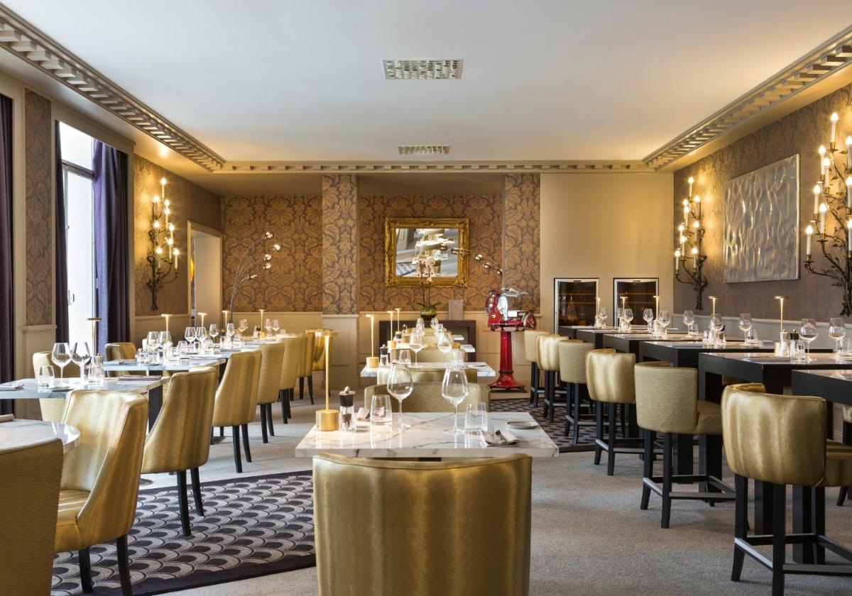 une salle à manger remplie de tables et de chaises dans l'établissement Hôtel Barrière le Grand Hôtel Enghien-les-Bains, à Enghien-les-Bains