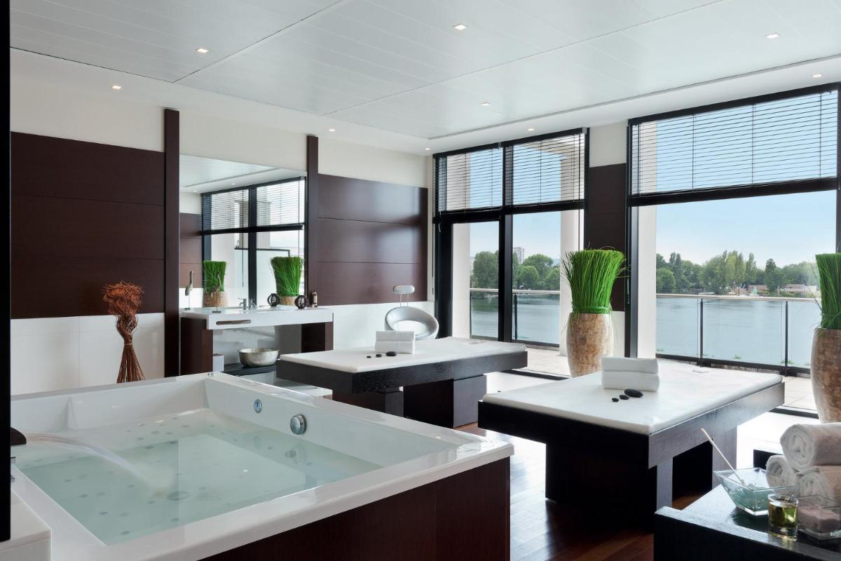 La salle de bains spacieuse est pourvue d'une grande baignoire et de fenêtres. dans l'établissement Hôtel Barrière le Grand Hôtel Enghien-les-Bains, à Enghien-les-Bains