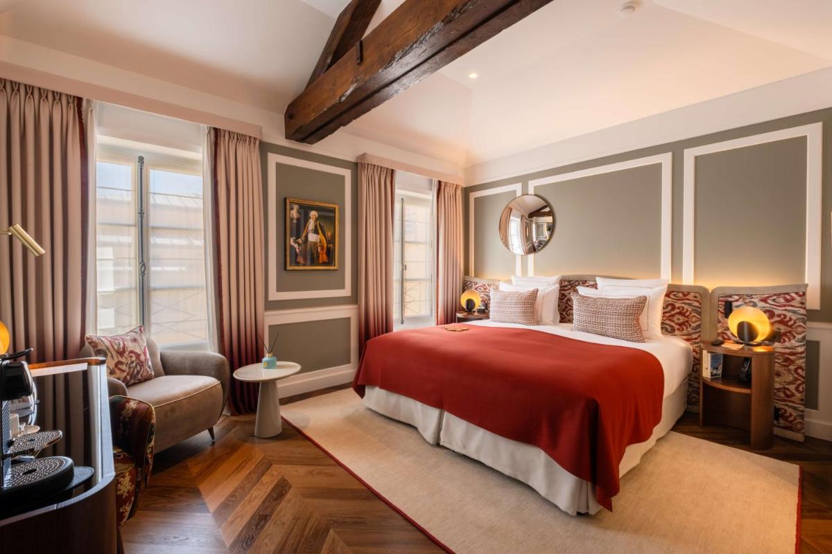 Un ou plusieurs lits dans un hébergement de l'établissement Hôtel Les Lumières - Relais & Châteaux