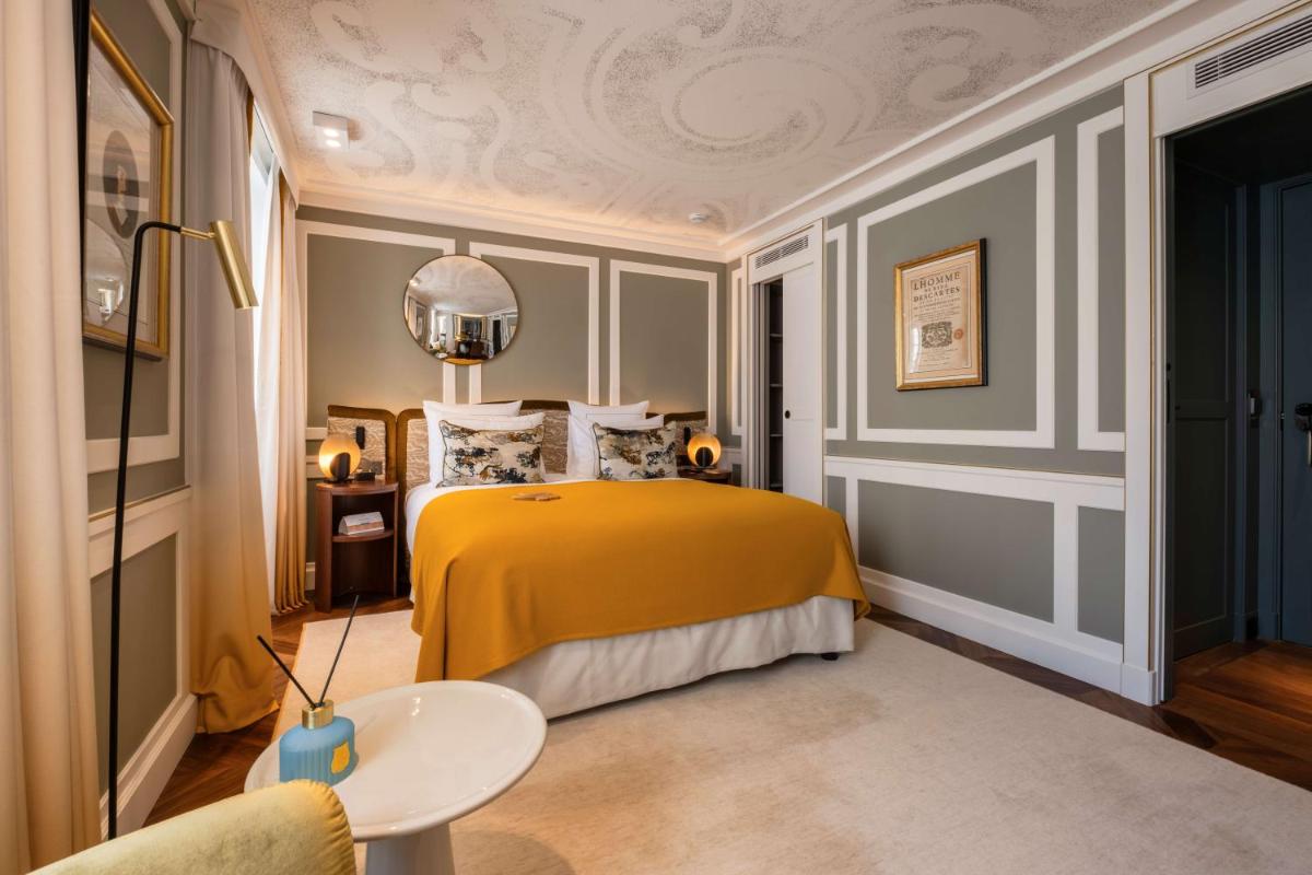 Un ou plusieurs lits dans un hébergement de l'établissement Hôtel Les Lumières - Relais & Châteaux