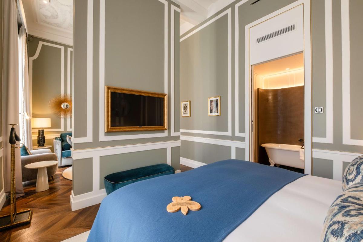 Un ou plusieurs lits dans un hébergement de l'établissement Hôtel Les Lumières - Relais & Châteaux