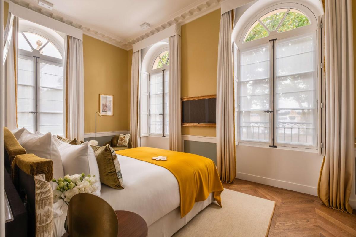 une chambre avec un lit et deux fenêtres dans l'établissement Hôtel Les Lumières - Relais & Châteaux, à Versailles 84 autres photos